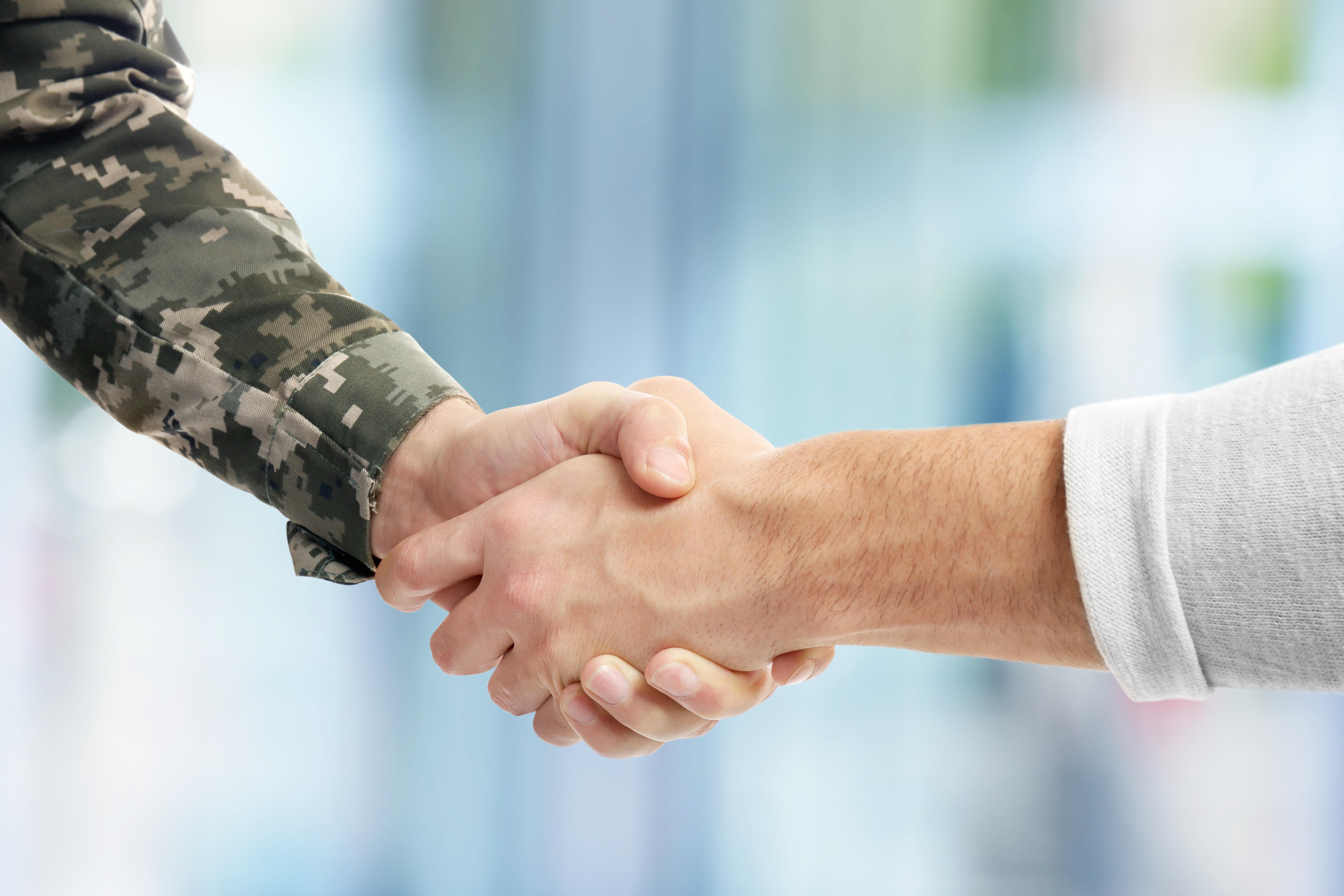 A handshake, with one person wearing military fatigues